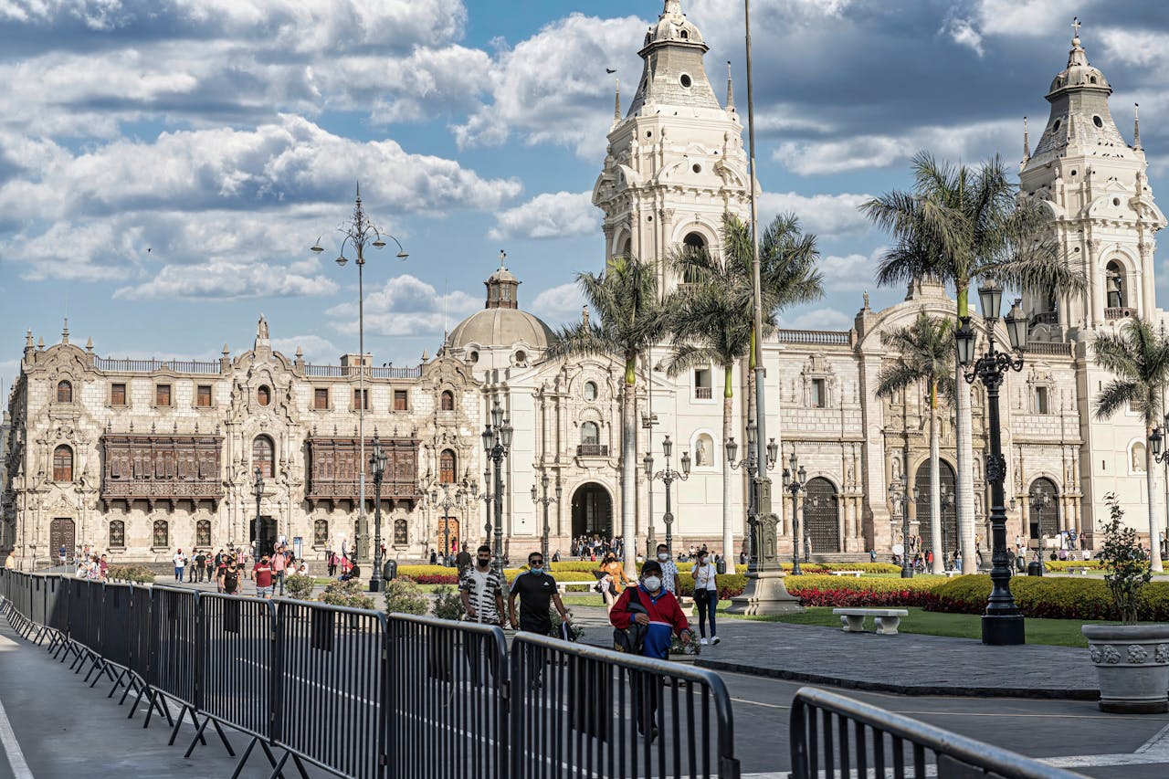 A bustling Plaza Mayor in Lima showcasing the historic Cathedral of Lima under blue skies.