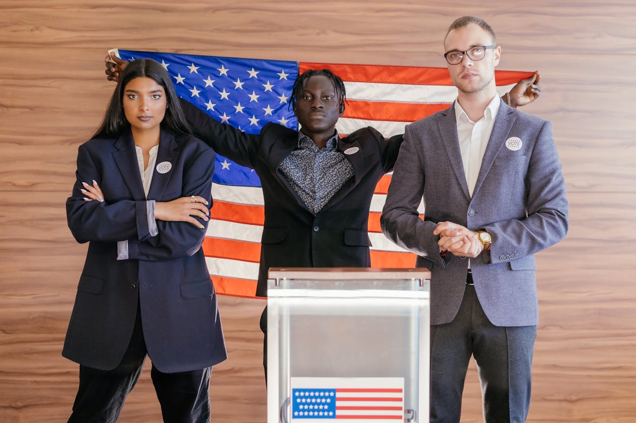 A group of diverse individuals standing confidently in front of an American flag at an election podium.
